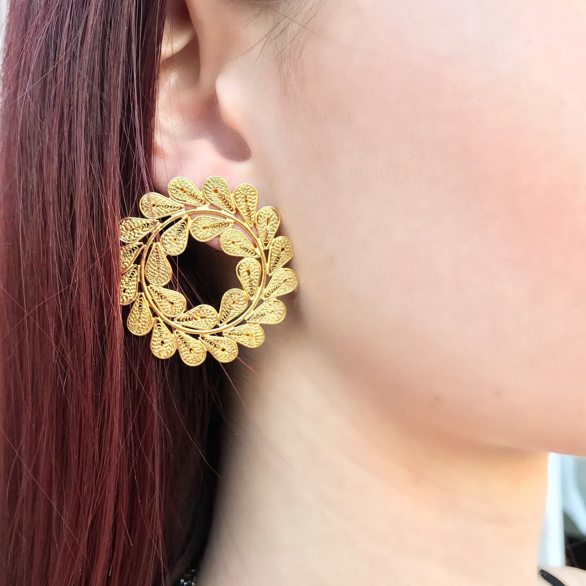 gold circle leafy earrings on model