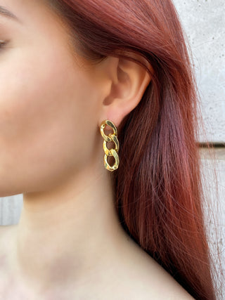 Gold chain trio earrings on model